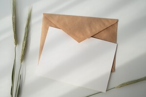 blank invitation card sitting on top of a brown envelope